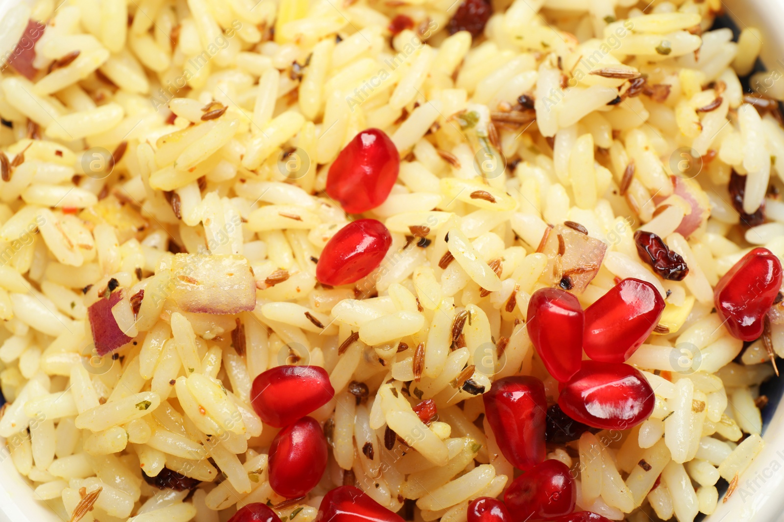 Photo of Tasty rice pilaf with pomegranate grains as background closeup