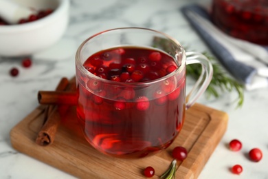 Photo of Tasty hot cranberry tea and fresh ingredients on white table