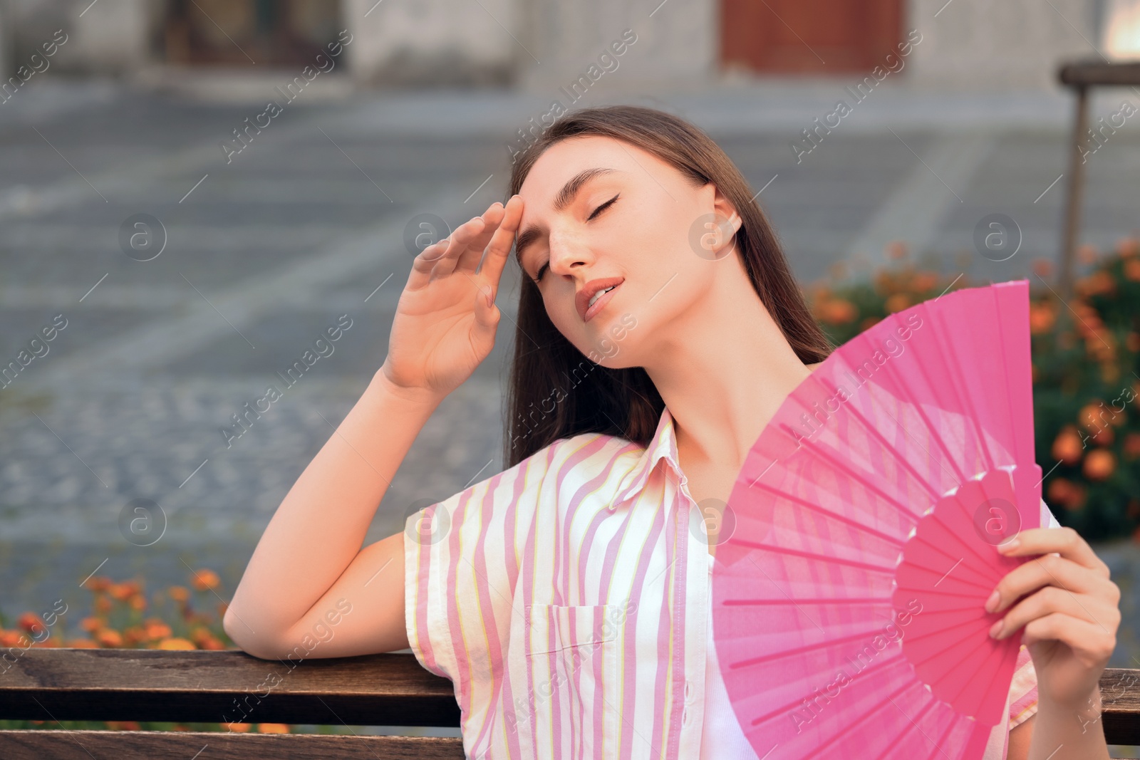 Photo of Woman with hand fan suffering from heat outdoors