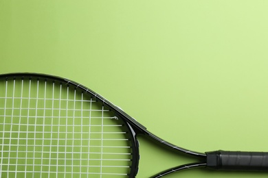 Tennis racket on green background, top view. Space for text