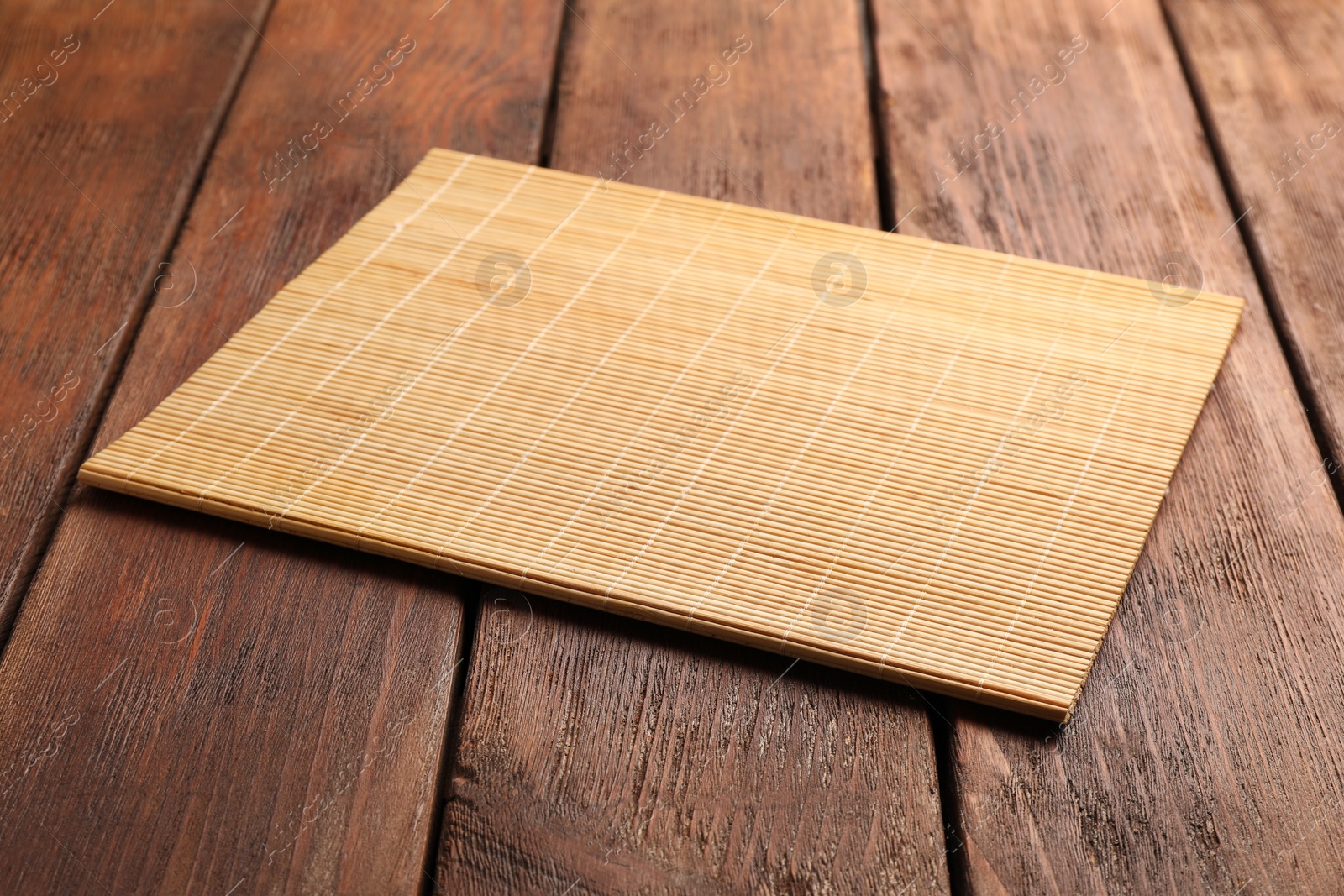 Photo of New clean bamboo mat on wooden table