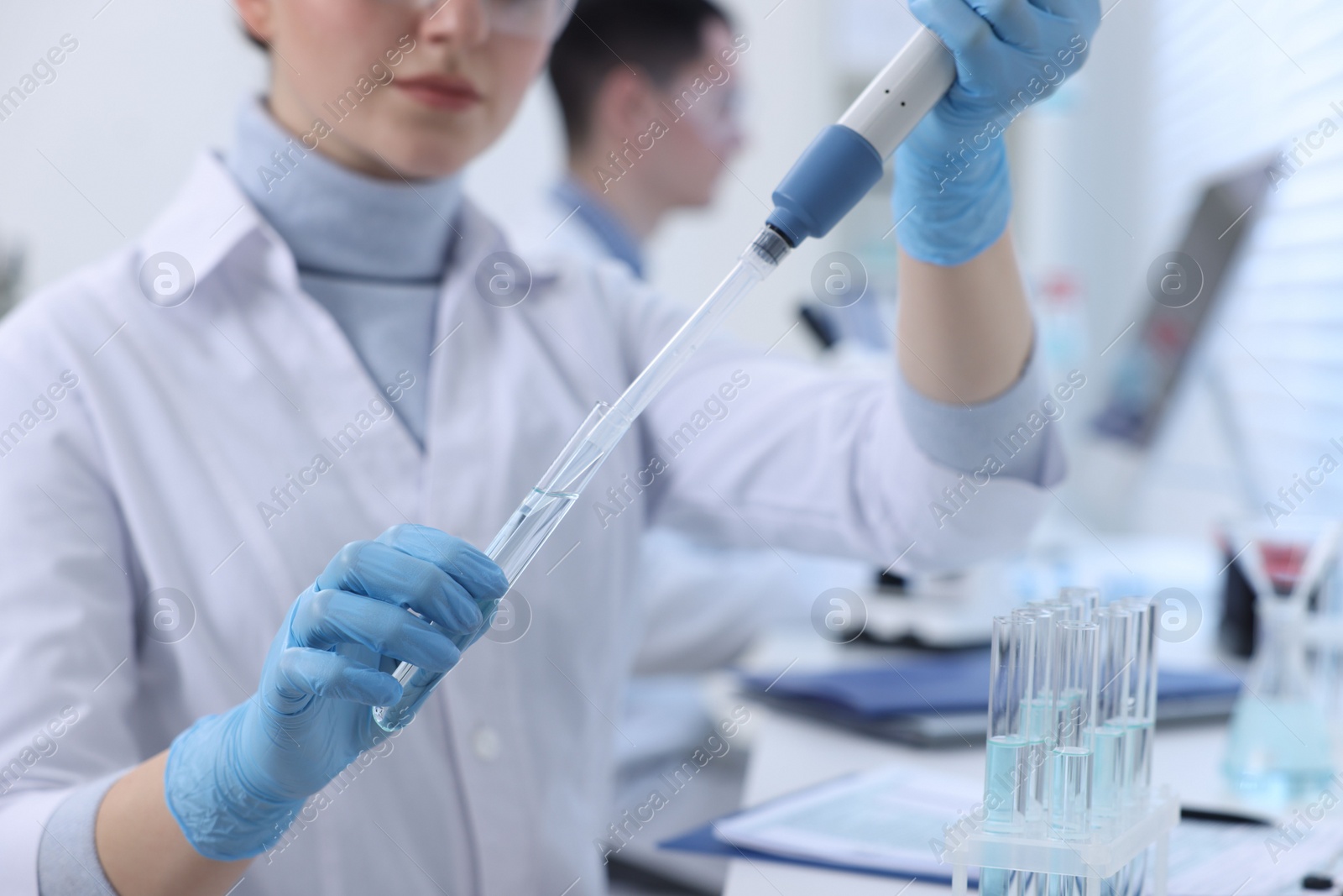 Photo of Scientist dripping sample into test tube in laboratory, closeup