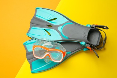 Pair of flippers and diving mask on color background, flat lay