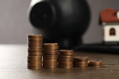 Photo of Saving money for house purchase. Stacks of coins wooden table, selective focus