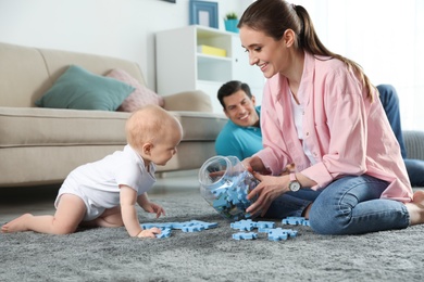 Photo of Happy mother playing with little baby on floor indoors