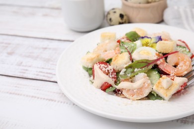 Photo of Delicious Caesar salad with shrimps on white wooden table, closeup. Space for text