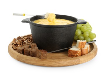 Photo of Fondue with tasty melted cheese, forks, grapes and pieces of bread isolated on white