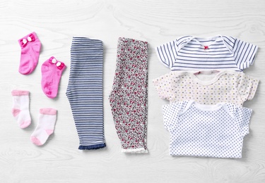 Photo of Set of baby clothes and accessories on wooden background, flat lay