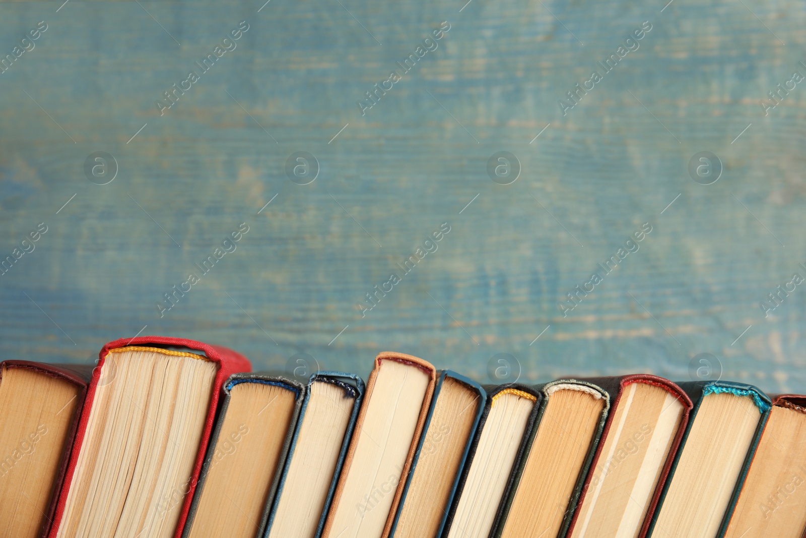 Photo of Collection of old books on blue wooden background. Space for text