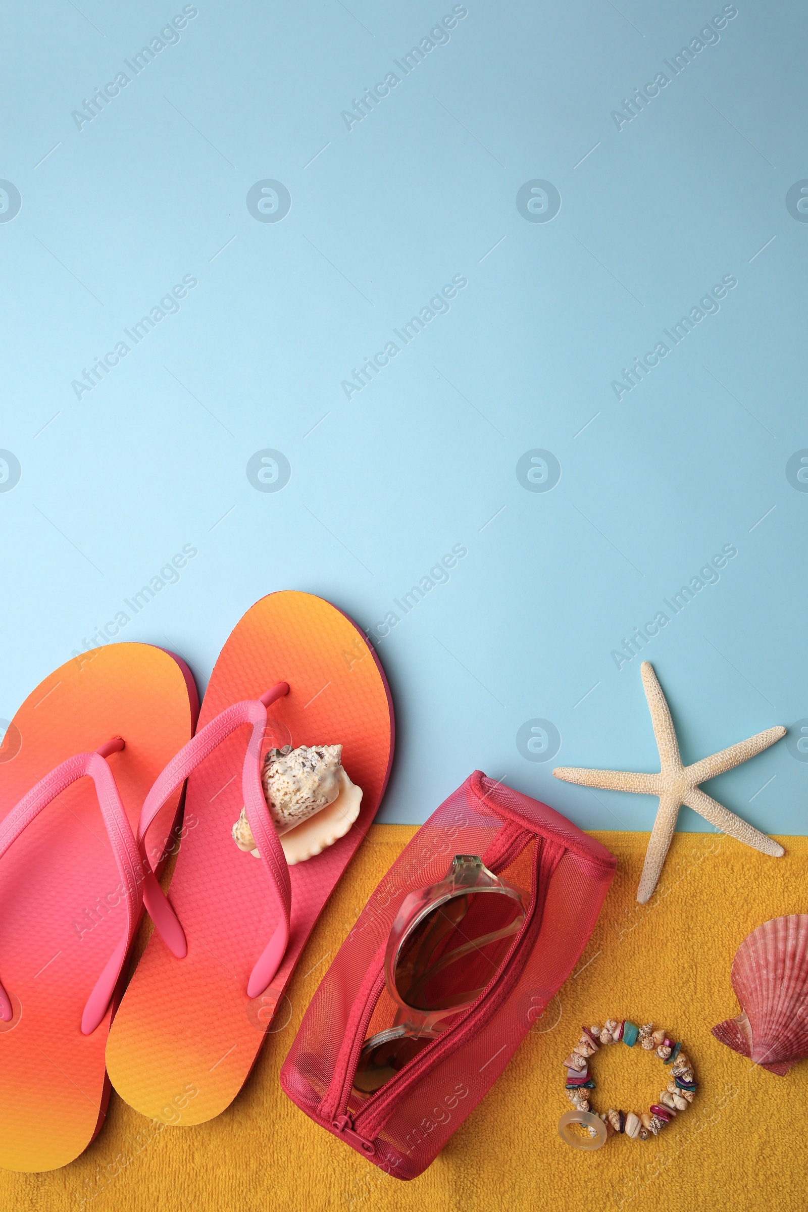 Photo of Flat lay composition with beach accessories on light blue background. Space for text