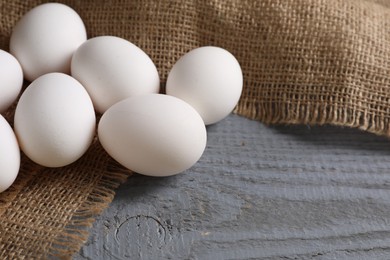 Photo of Fresh chicken eggs on grey wooden table, closeup. Space for text