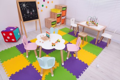 Stylish kindergarten interior with toys and modern furniture