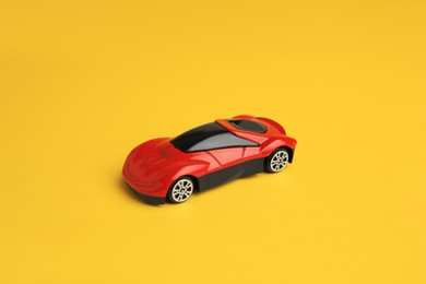 Photo of One red car on yellow background. Children`s toy