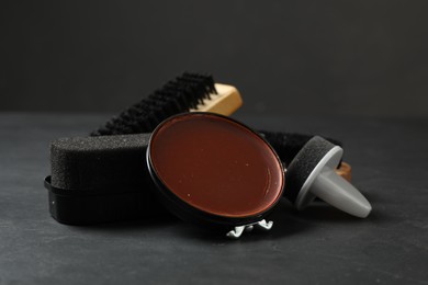 Photo of Composition with shoe care accessories on black table, closeup