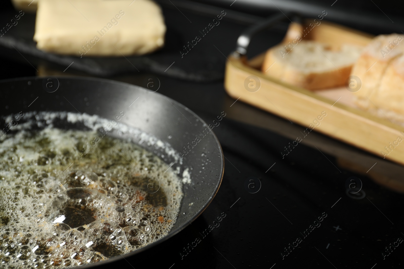 Photo of Melting butter in frying pan on cooktop, closeup. Space for text