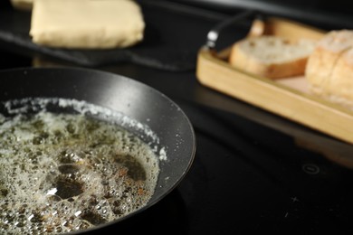 Photo of Melting butter in frying pan on cooktop, closeup. Space for text