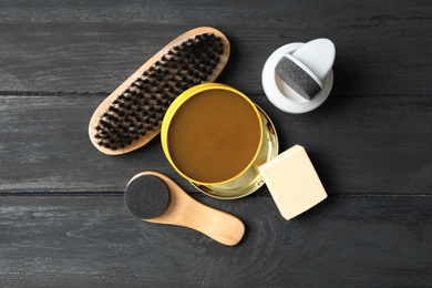 Photo of Flat lay composition with shoe care accessories on black wooden background