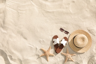 Photo of Flat lay composition with beach accessories on sand. Space for text