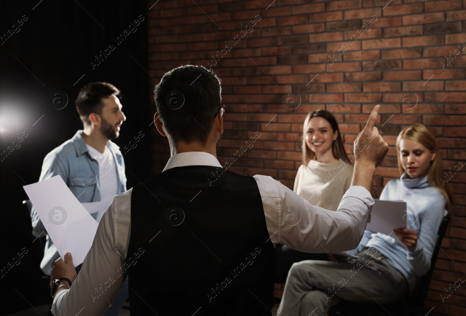 Photo of Professional actors reading their scripts during rehearsal in theatre