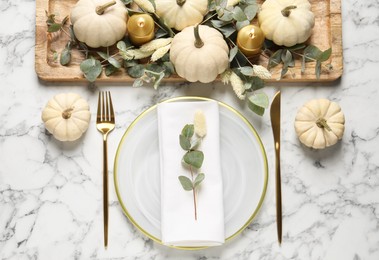 Festive table setting with autumn decor on white marble background, flat lay