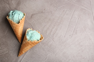 Photo of Delicious spirulina ice cream cones on grey background. Space for text
