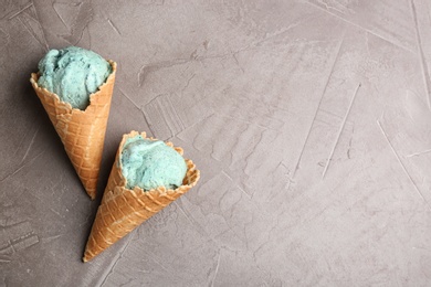 Delicious spirulina ice cream cones on grey background. Space for text