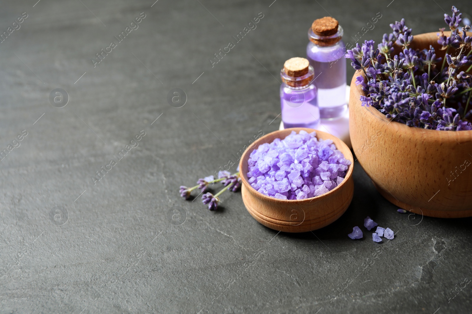 Photo of Cosmetic products and lavender flowers on dark grey background. Space for text