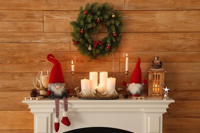Cute Christmas gnomes and festive decorations on mantelpiece in room
