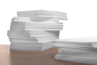 Stacks of paper sheets on wooden table against white background