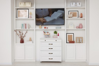 TV and shelves with different decor in room. Interior design