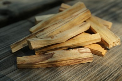 Photo of Palo santo sticks on wooden table outdoors