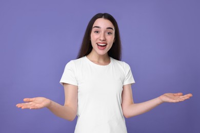 Photo of Portrait of happy surprised woman on violet background