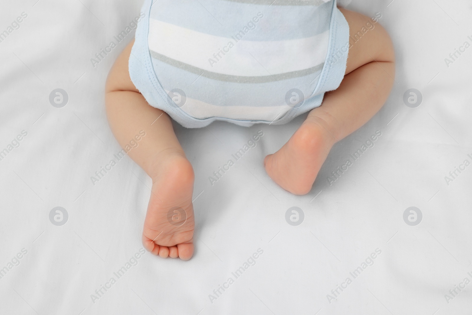 Photo of Newborn baby lying on white blanket, top view