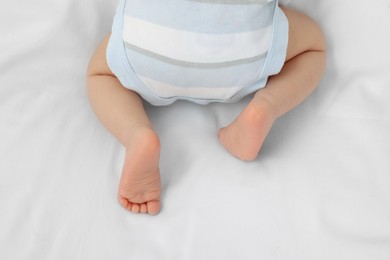 Photo of Newborn baby lying on white blanket, top view