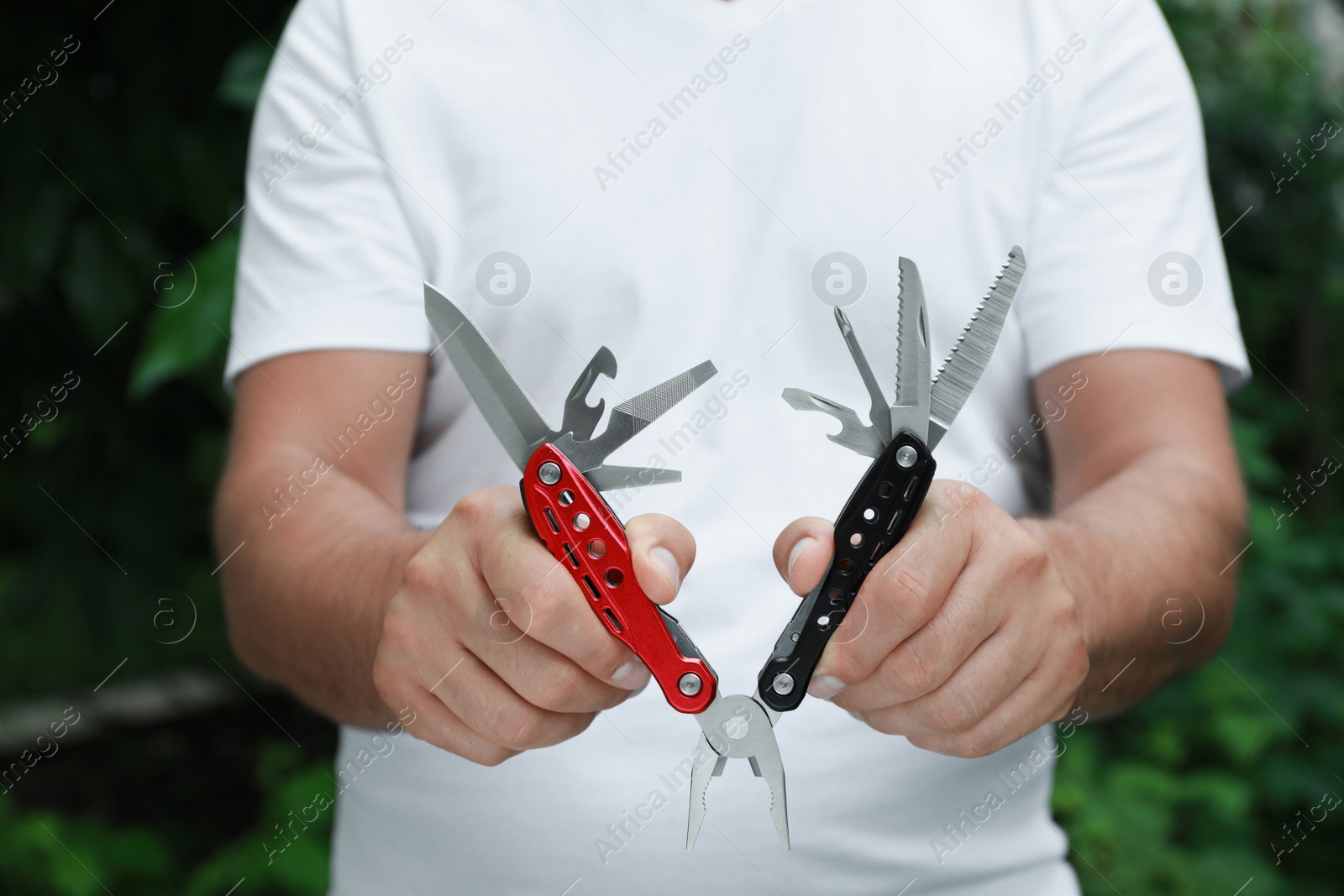 Photo of Man holding compact portable multitool outdoors, closeup