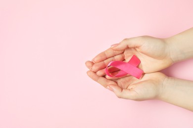 Breast cancer awareness. Woman with pink ribbon on color background, top view. Space for text