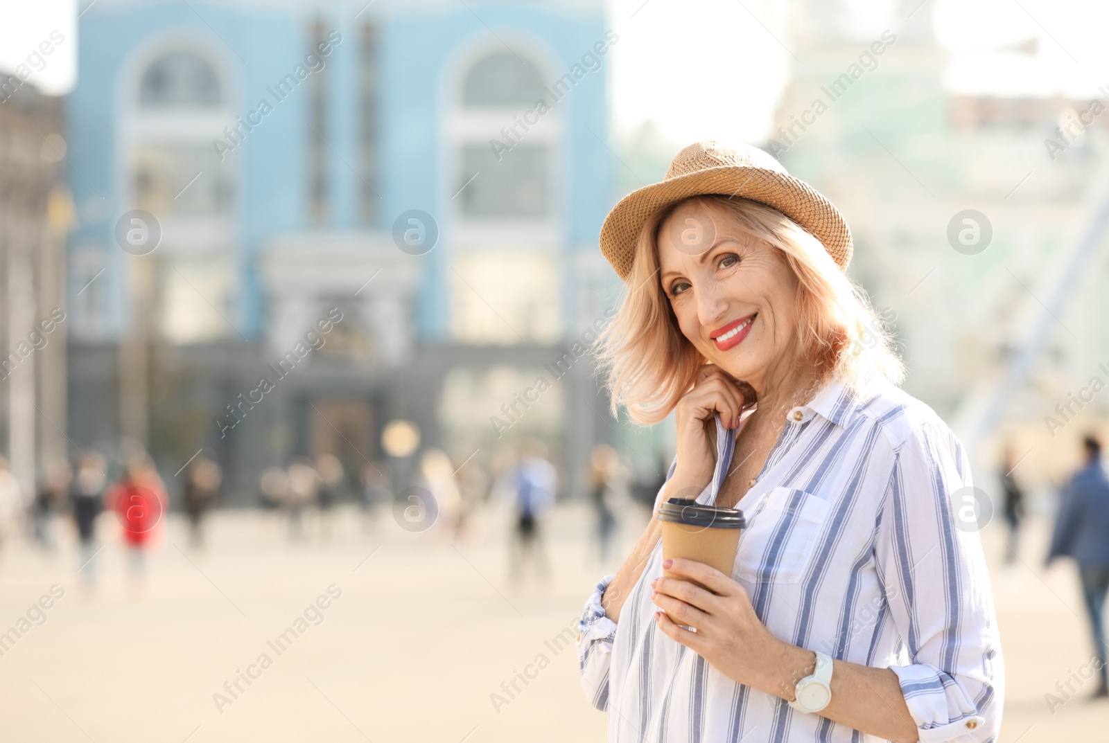 Photo of Beautiful mature woman with cup of coffee outdoors