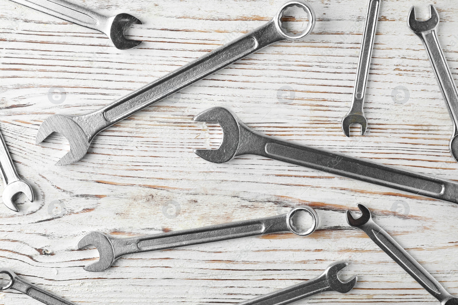 Photo of New wrenches on wooden background, top view. Plumber tools