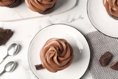 Photo of Delicious fresh chocolate cupcake on white marble table, flat lay