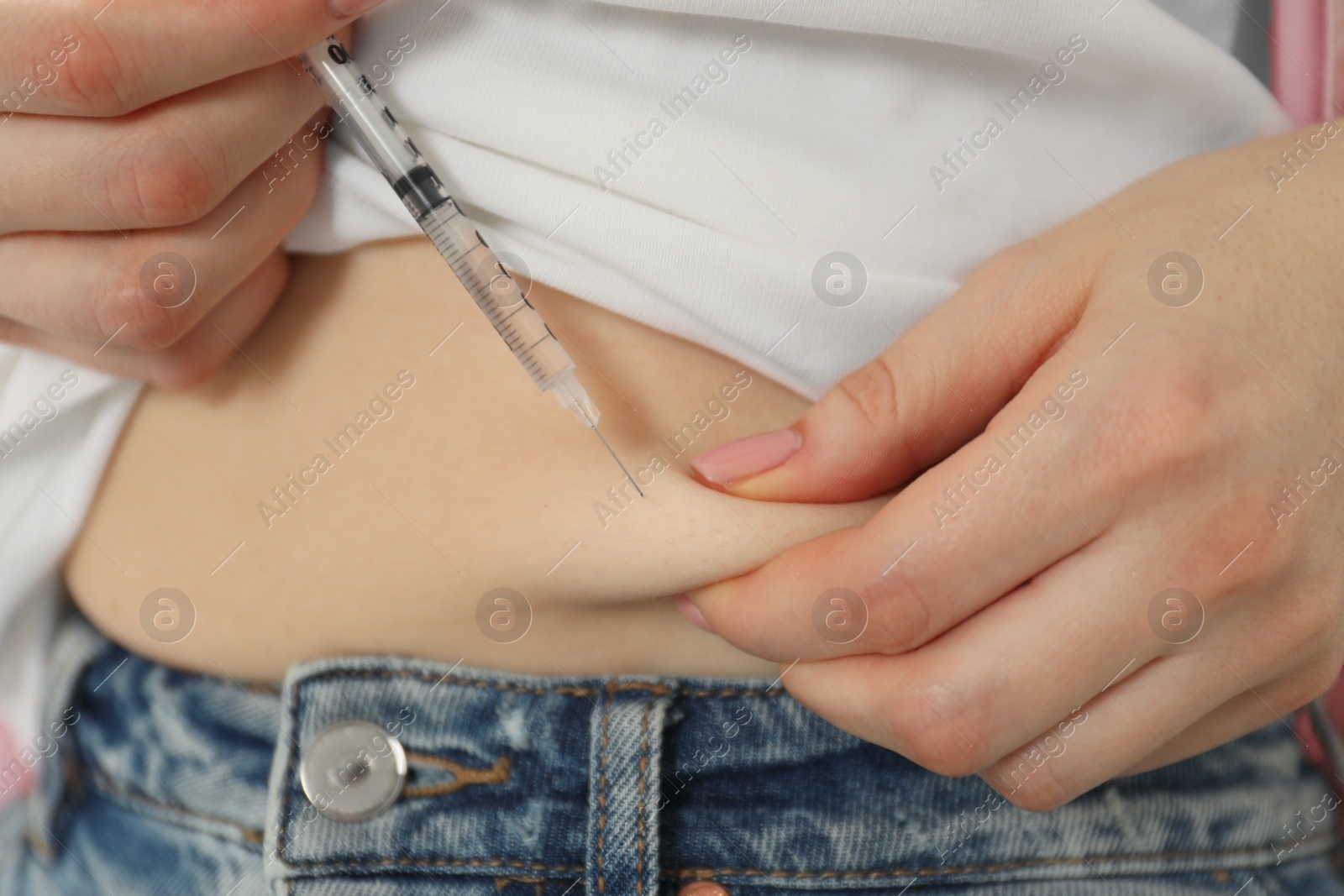 Photo of Diabetes. Woman making insulin injection into her belly, closeup