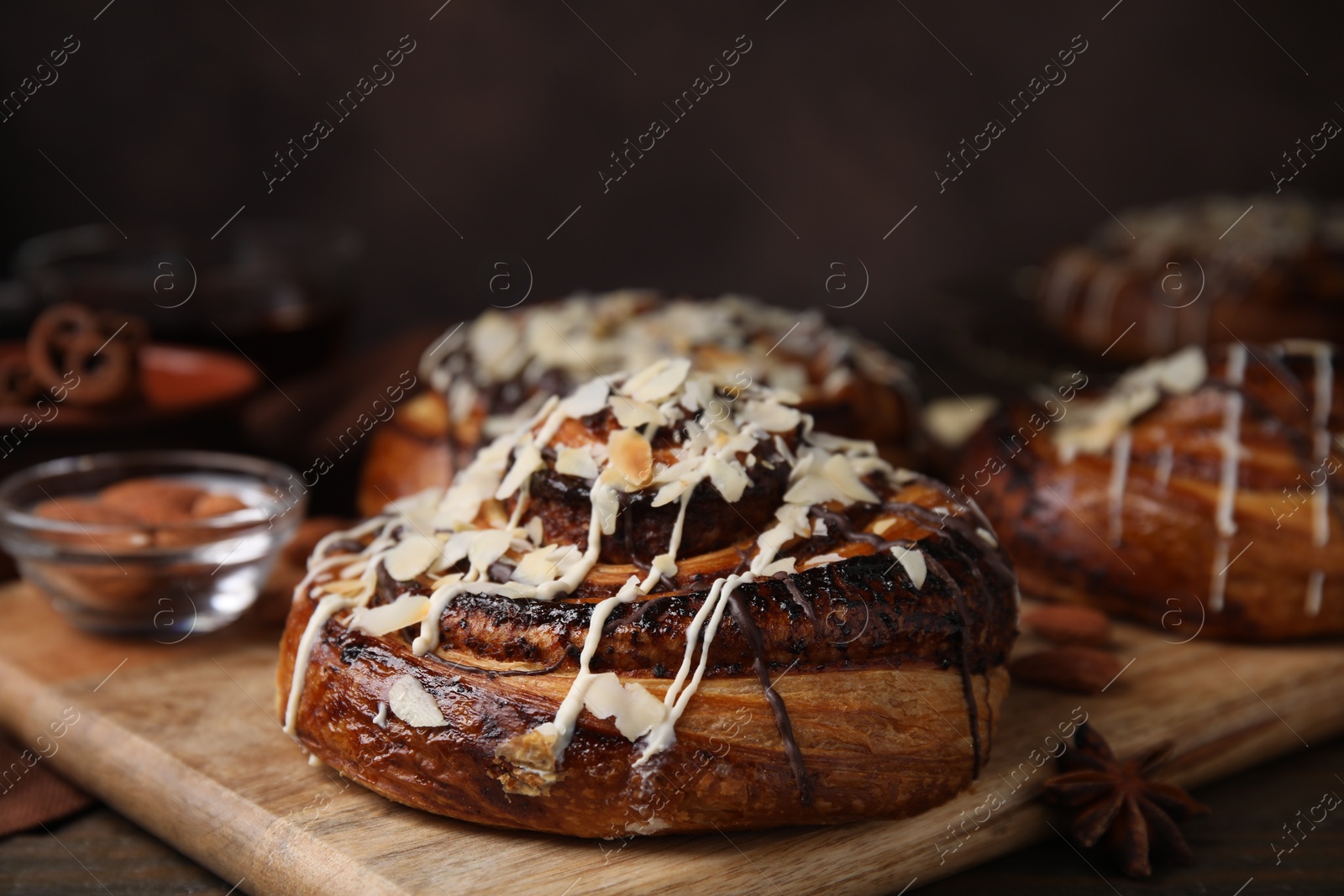 Photo of Delicious rolls with toppings and nuts on wooden table, closeup. Sweet buns