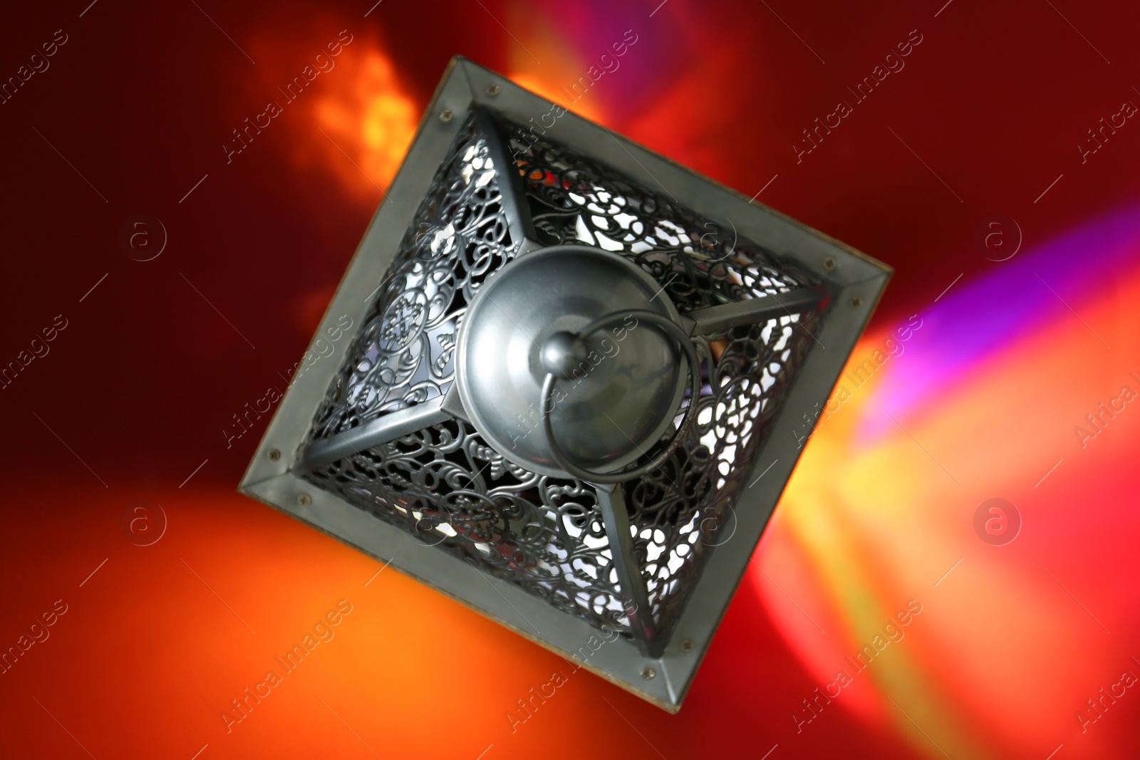 Photo of Decorative Arabic lantern on red background, top view