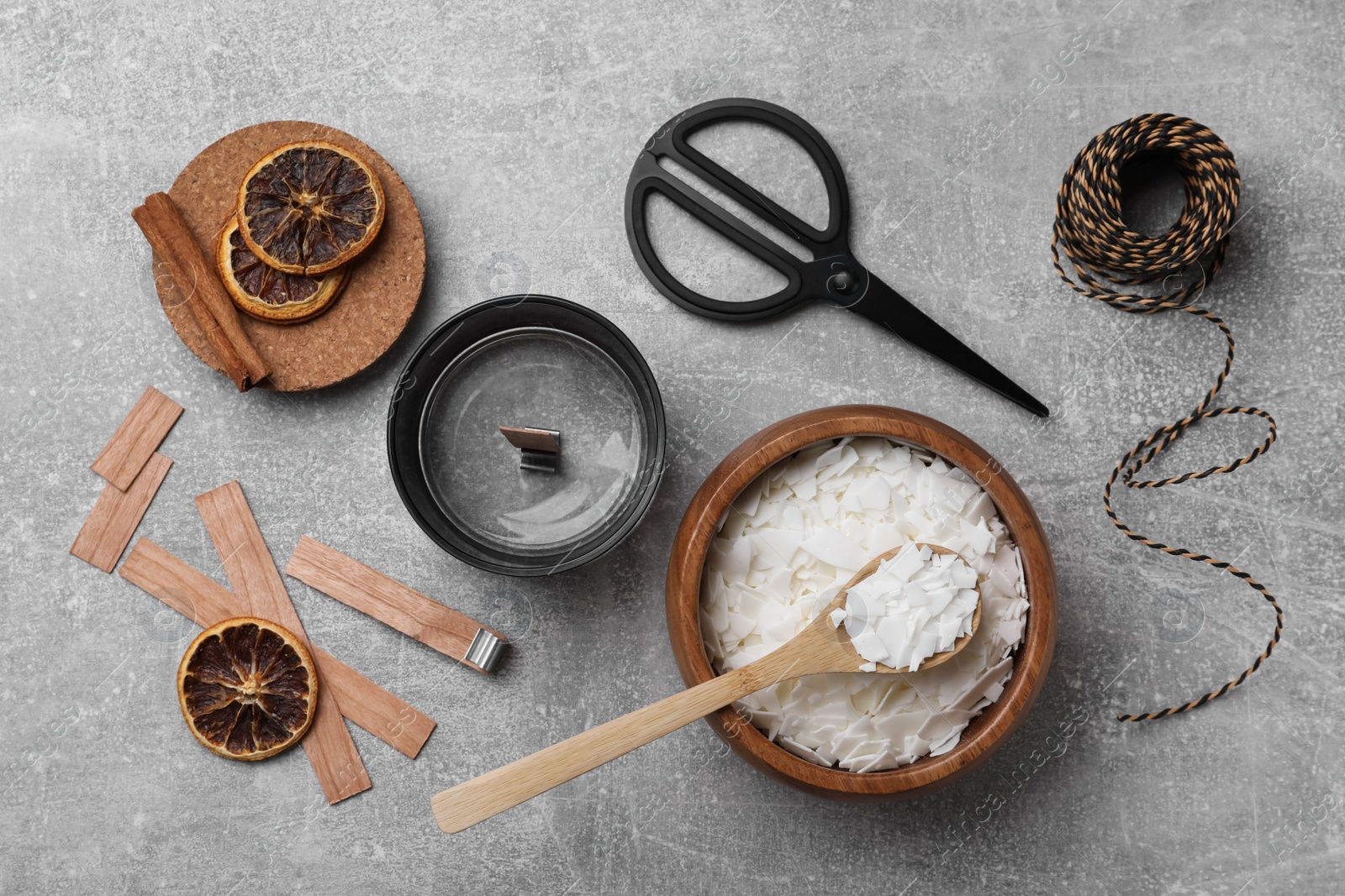 Photo of Flat lay composition with ingredients for homemade candles on grey background