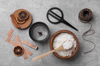 Flat lay composition with ingredients for homemade candles on grey background