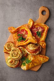 Photo of Various delicious puff pastry with tasty filling on grey table, top view