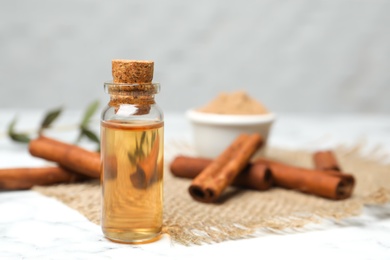 Photo of Bottle with cinnamon essential oil on table