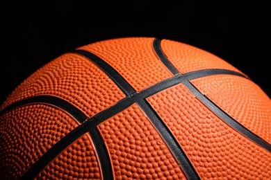 Orange basketball ball on black background, closeup