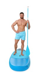 Photo of Handsome man with paddle on blue SUP board against white background