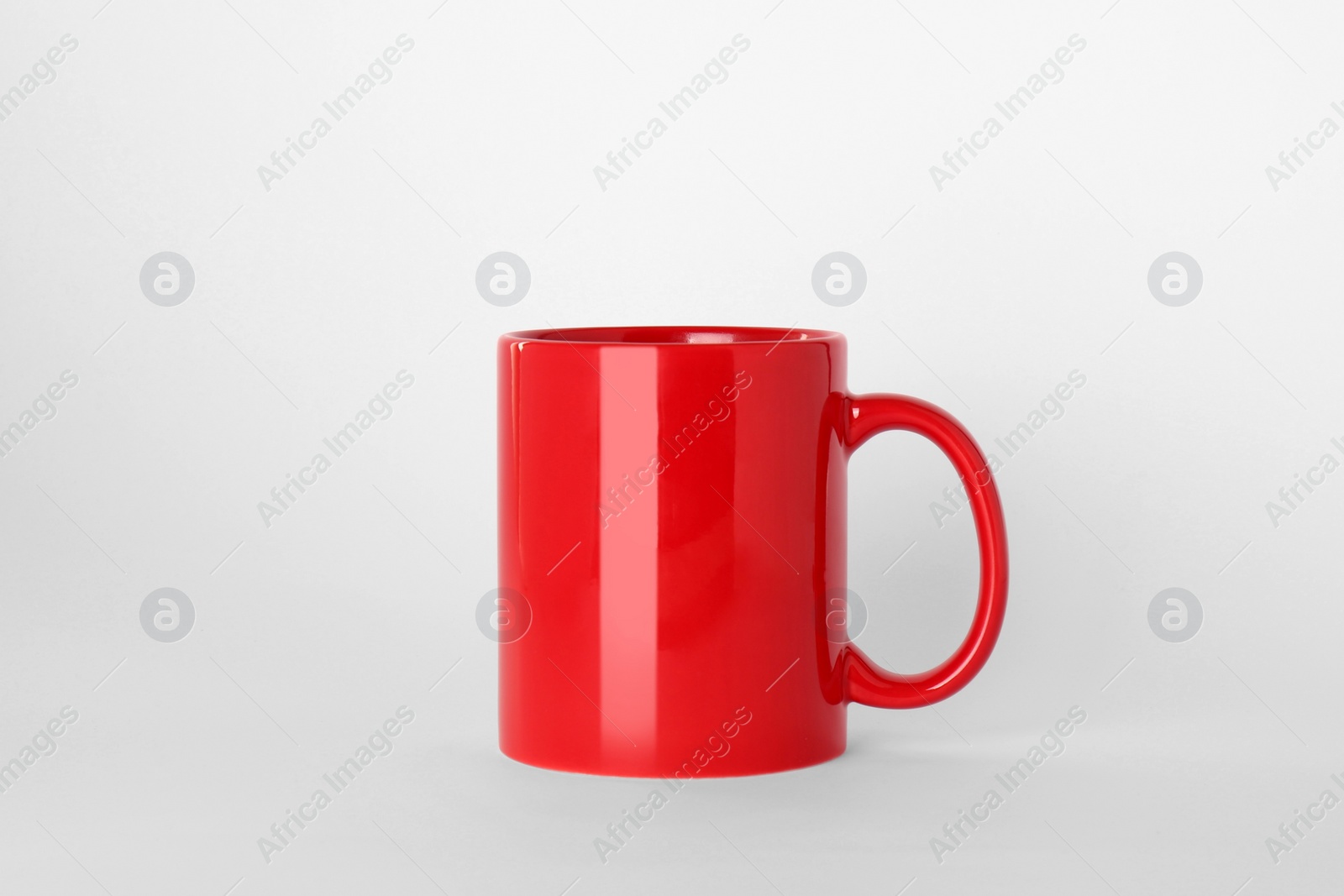 Blank red ceramic mug on light background Photo of Blank red ceramic mug on light background