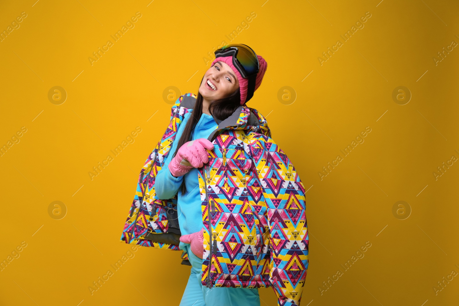 Photo of Woman wearing stylish winter sport clothes on yellow background